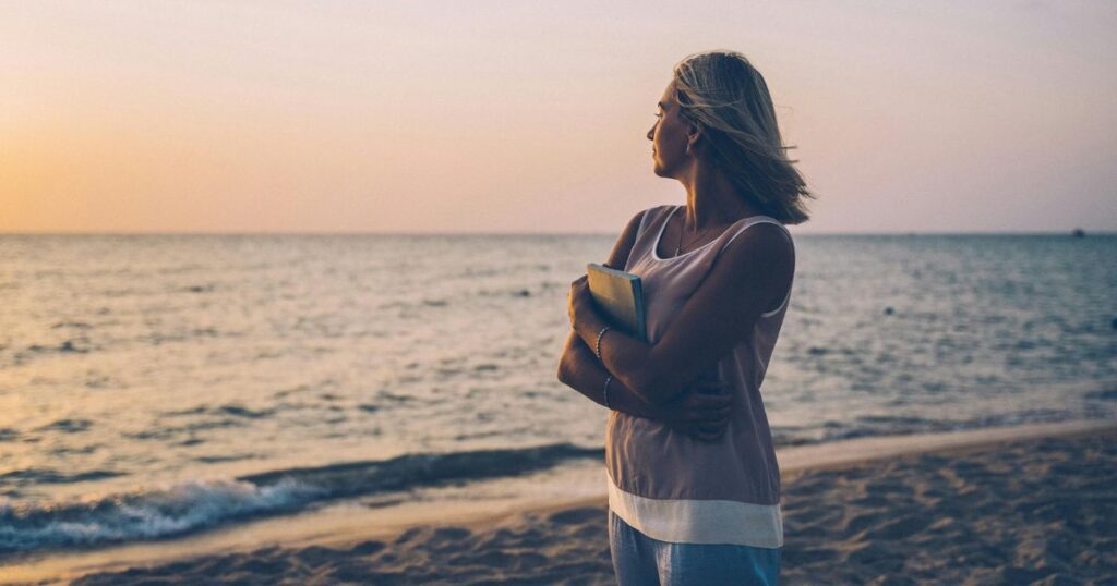 Woman walking calmly on the beach / Self-Love Boundaries: Powerful Ways to Protect Your Peace