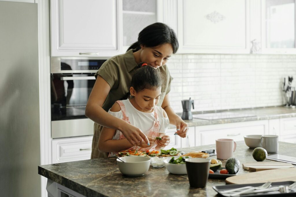 A mother and daughter preparing food together in the kitchen, sharing everyday moments of care and connection in life after divorce.