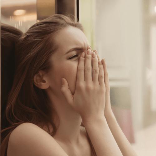 Woman distraught, crying. Face covered.