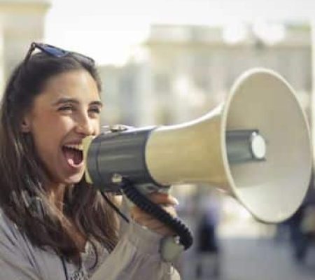 Woman calling through a megaphone join this membership