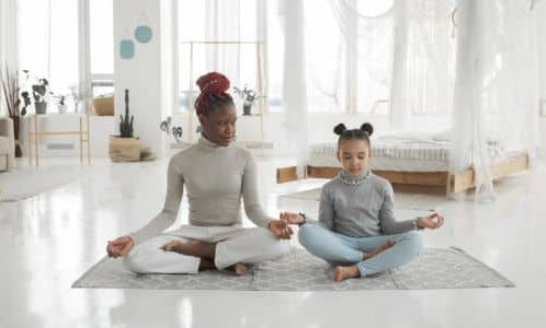 Mama and daughter meditating